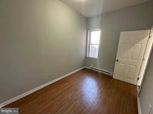 a view of a room with wooden floor and window