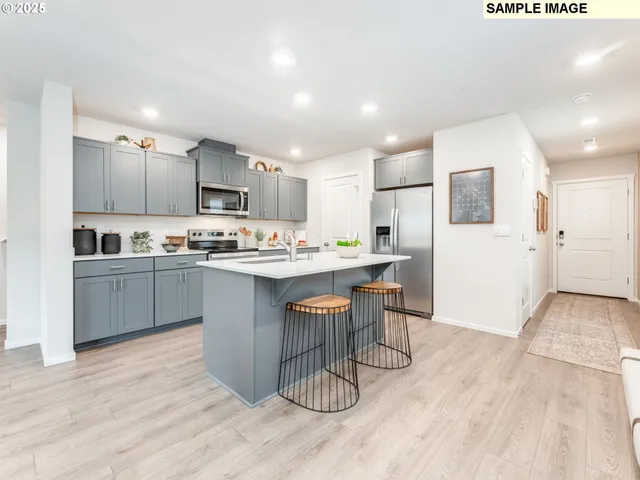 a kitchen with a sink cabinets stainless steel appliances and wooden floor