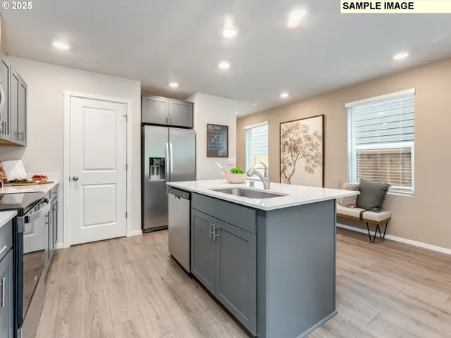 a kitchen with kitchen island granite countertop a sink cabinets and wooden floor