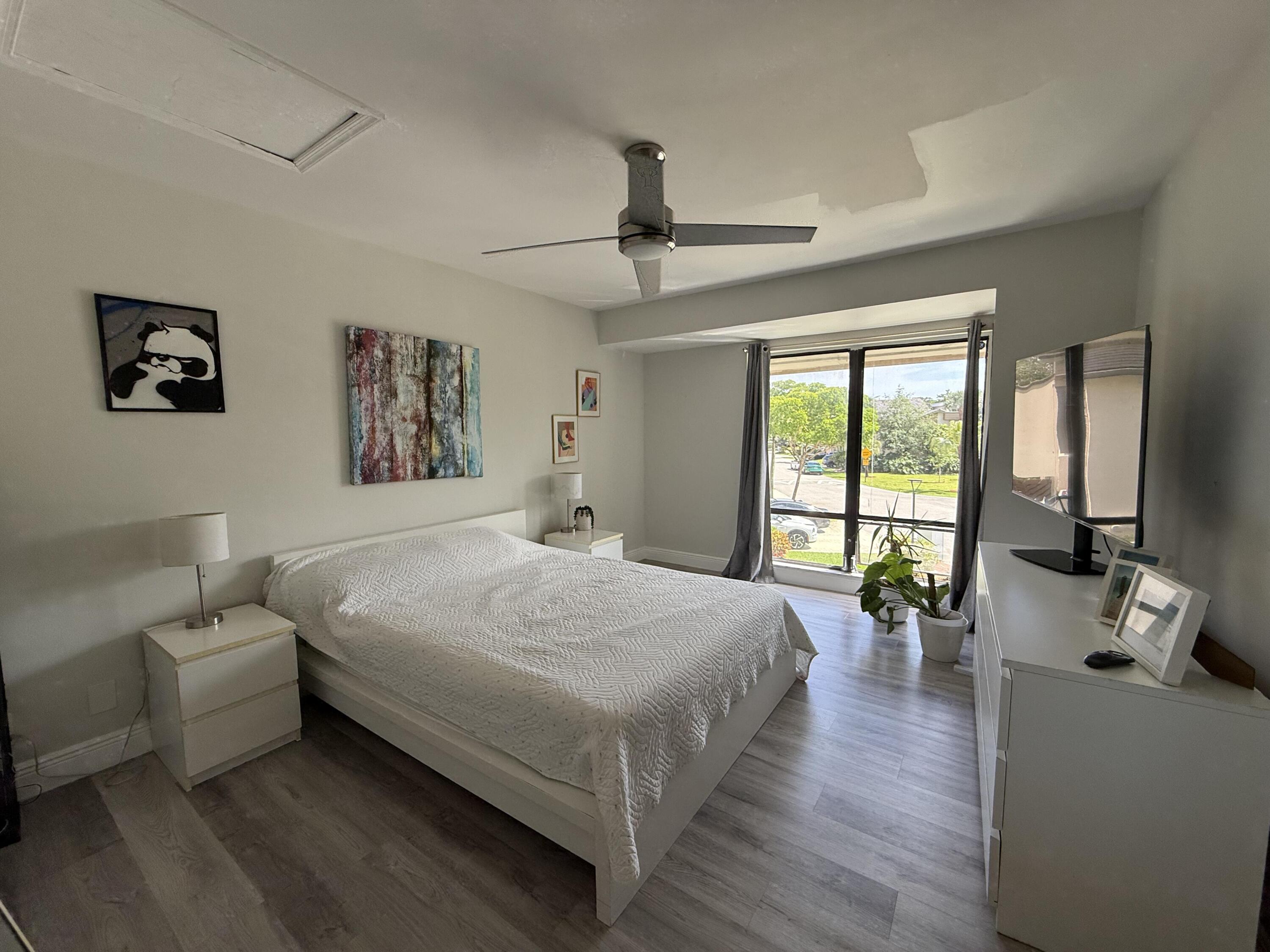 22874 Ironwedge Drive Boca Raton, FL 33433 - Photo 38 of 52 a spacious bedroom with a bed a couch and a large window