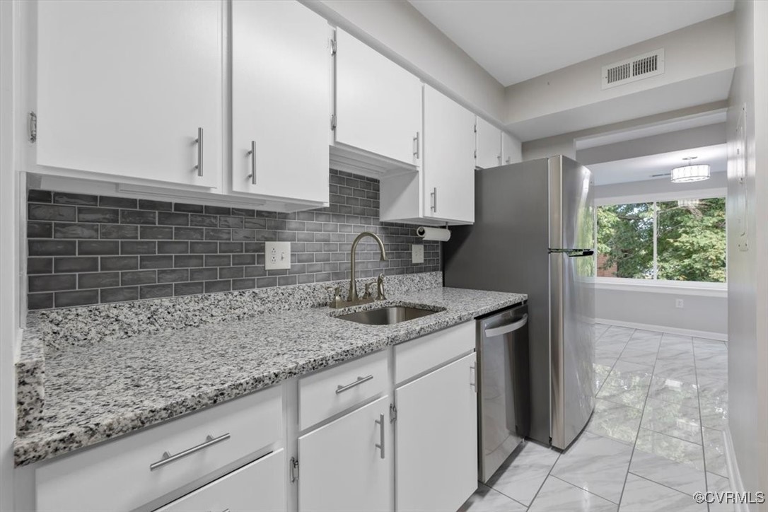 1501 Thistle Road, Unit 203 Richmond, VA 23238 - Photo 7 of 30 a kitchen with granite countertop a sink a stove and cabinets