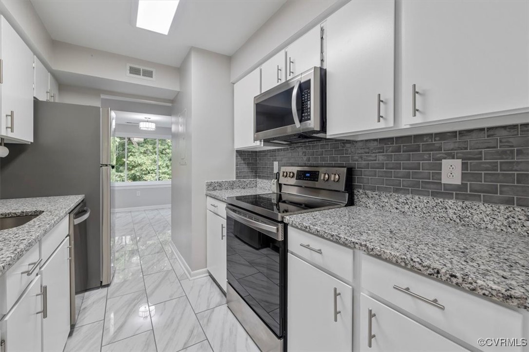 1501 Thistle Road, Unit 203 Richmond, VA 23238 - Photo 8 of 30 a kitchen with stainless steel appliances granite countertop a sink stove and microwave