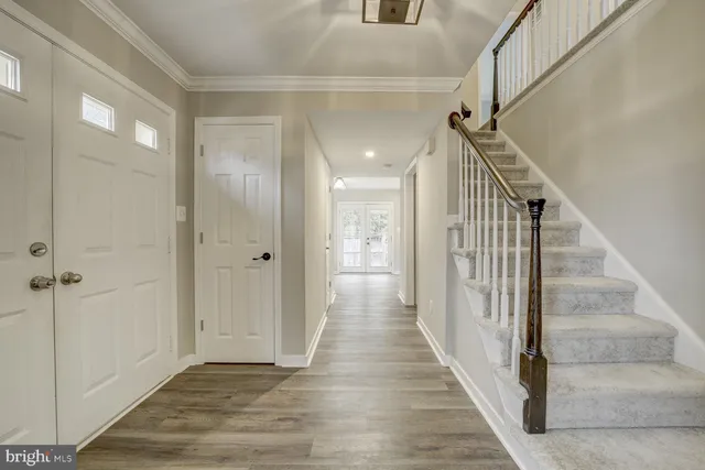 a view of a hallway with wooden floor and entryway