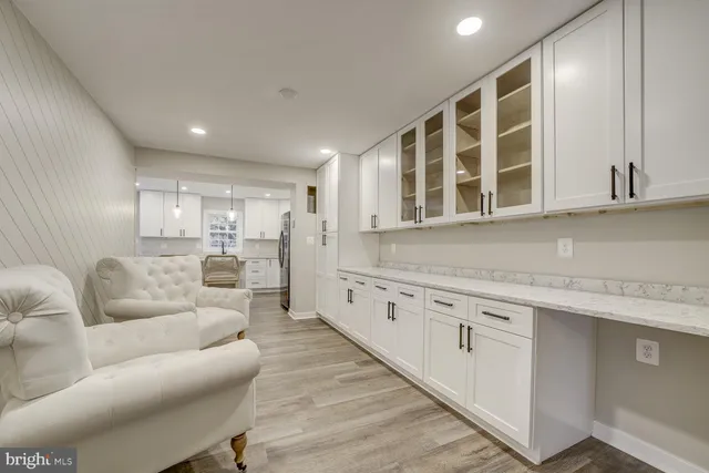 a large living room with stainless steel appliances granite countertop a couch a stove a sink and a refrigerator with wooden floor