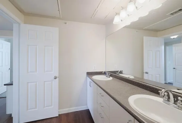 a white bath tub sitting next to a white toilet and vanity