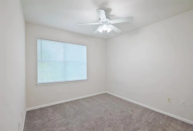 an empty room with a ceiling fan and a fan