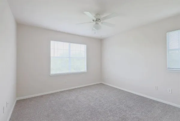 an empty room with a ceiling fan and a window