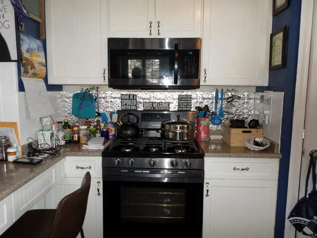 a kitchen with stainless steel appliances a stove and a microwave