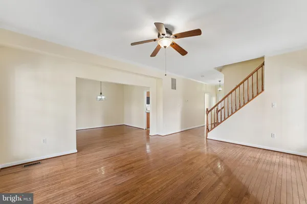 a view of an empty room with wooden floor and closet