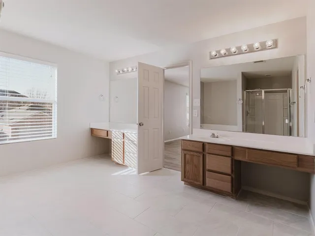 a spacious bathroom with a double vanity sink mirror and bathtub