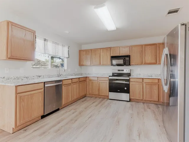 a kitchen with granite countertop white cabinets and stainless steel appliances