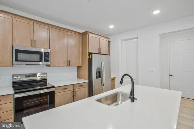 a kitchen with stainless steel appliances a sink microwave and cabinets