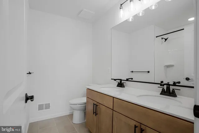 a bathroom with a sink a toilet and a mirror