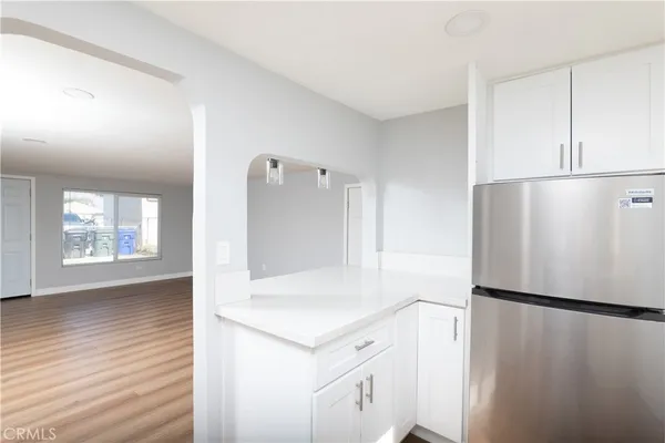 a view of kitchen with refrigerator cabinets and wooden floor
