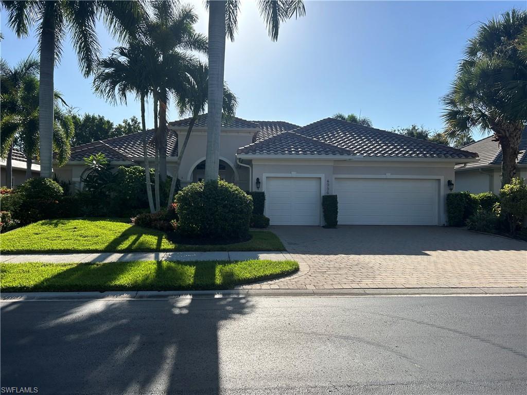 4956 Rustic Oaks Circle Naples, FL 34105 - Photo 3 of 10 front view of house with a yard and potted plants
