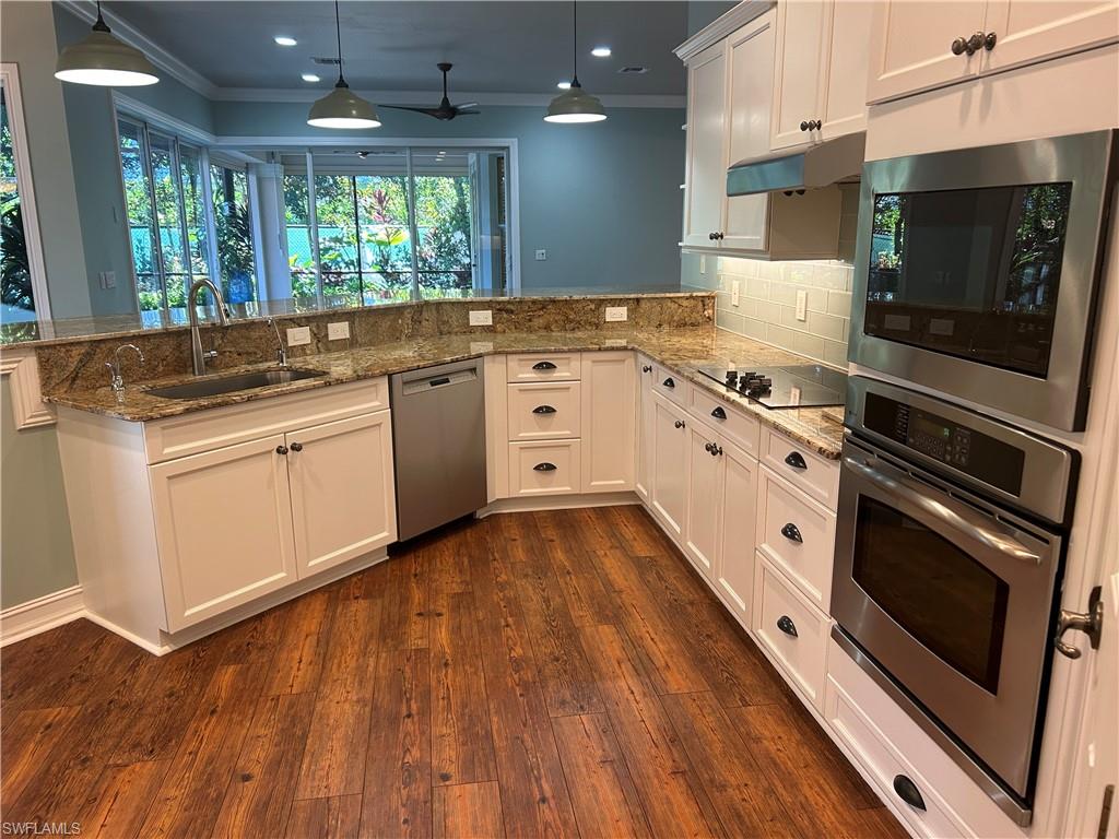 4956 Rustic Oaks Circle Naples, FL 34105 - Photo 5 of 10 a kitchen with granite countertop a stove and a sink