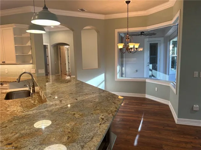 a view of a kitchen with a sink and dishwasher with wooden floor