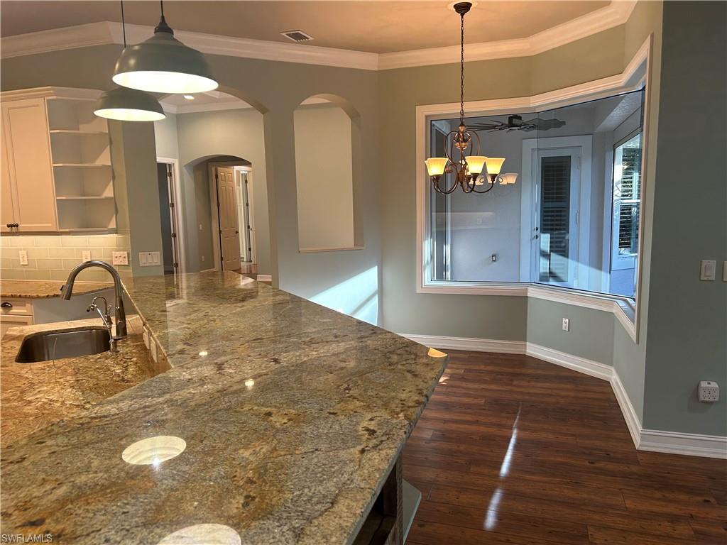 4956 Rustic Oaks Circle Naples, FL 34105 - Photo 8 of 10 a view of a kitchen with a sink and dishwasher with wooden floor