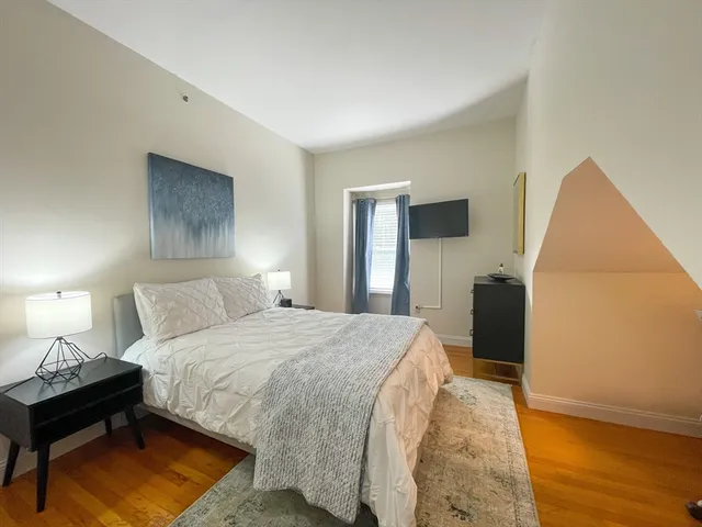 a bedroom with a bed and a night stand