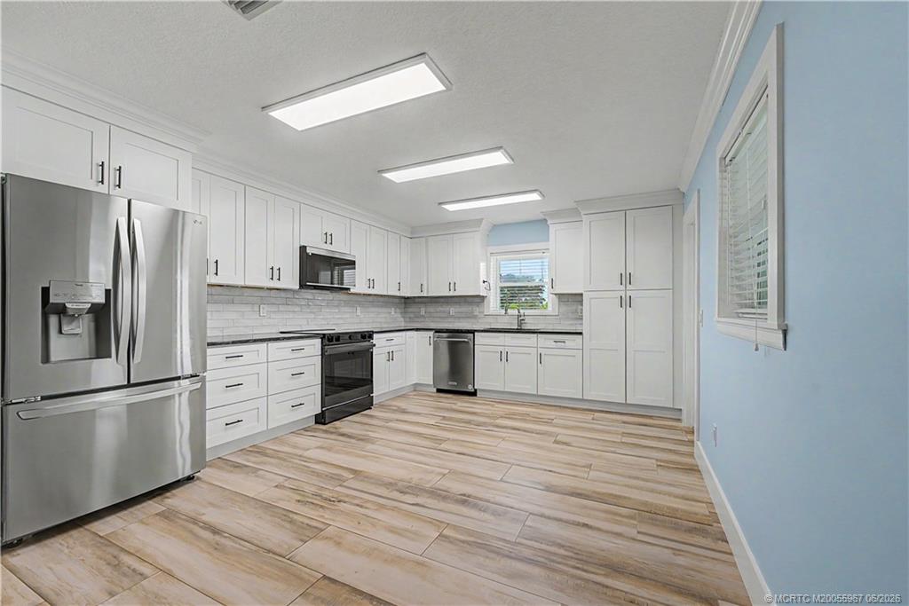 8200 Southwest Springhaven Avenue Indiantown, FL 34956 - Photo 5 of 35 a large kitchen with cabinets stainless steel appliances and a counter space