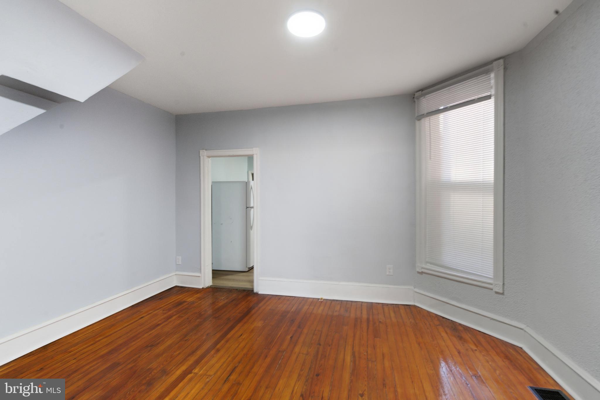 5632 Addison Street Philadelphia, PA 19143 - Photo 13 of 14 an empty room with wooden floor and windows