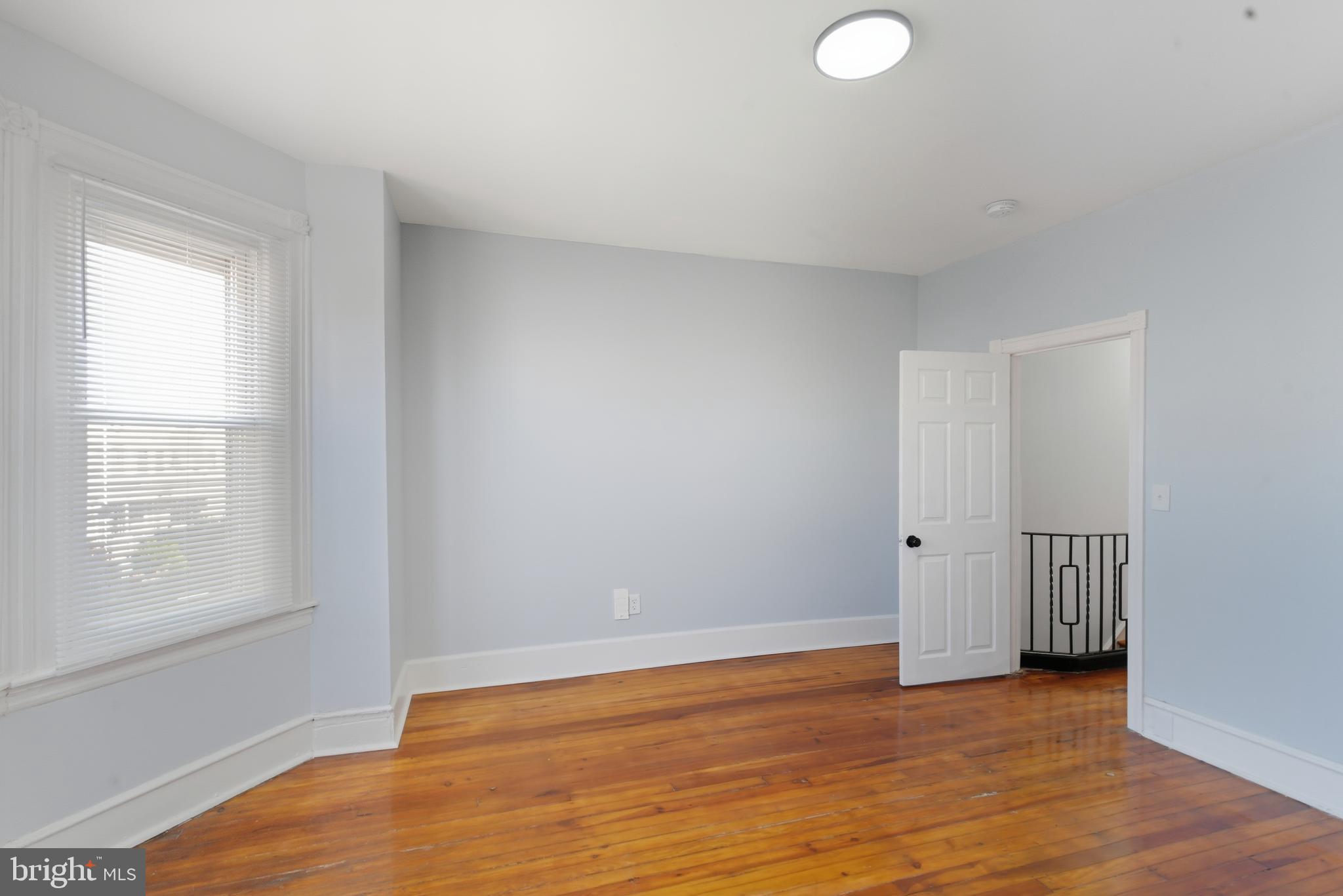 5632 Addison Street Philadelphia, PA 19143 - Photo 14 of 14 a view of an empty room with wooden floor and a window