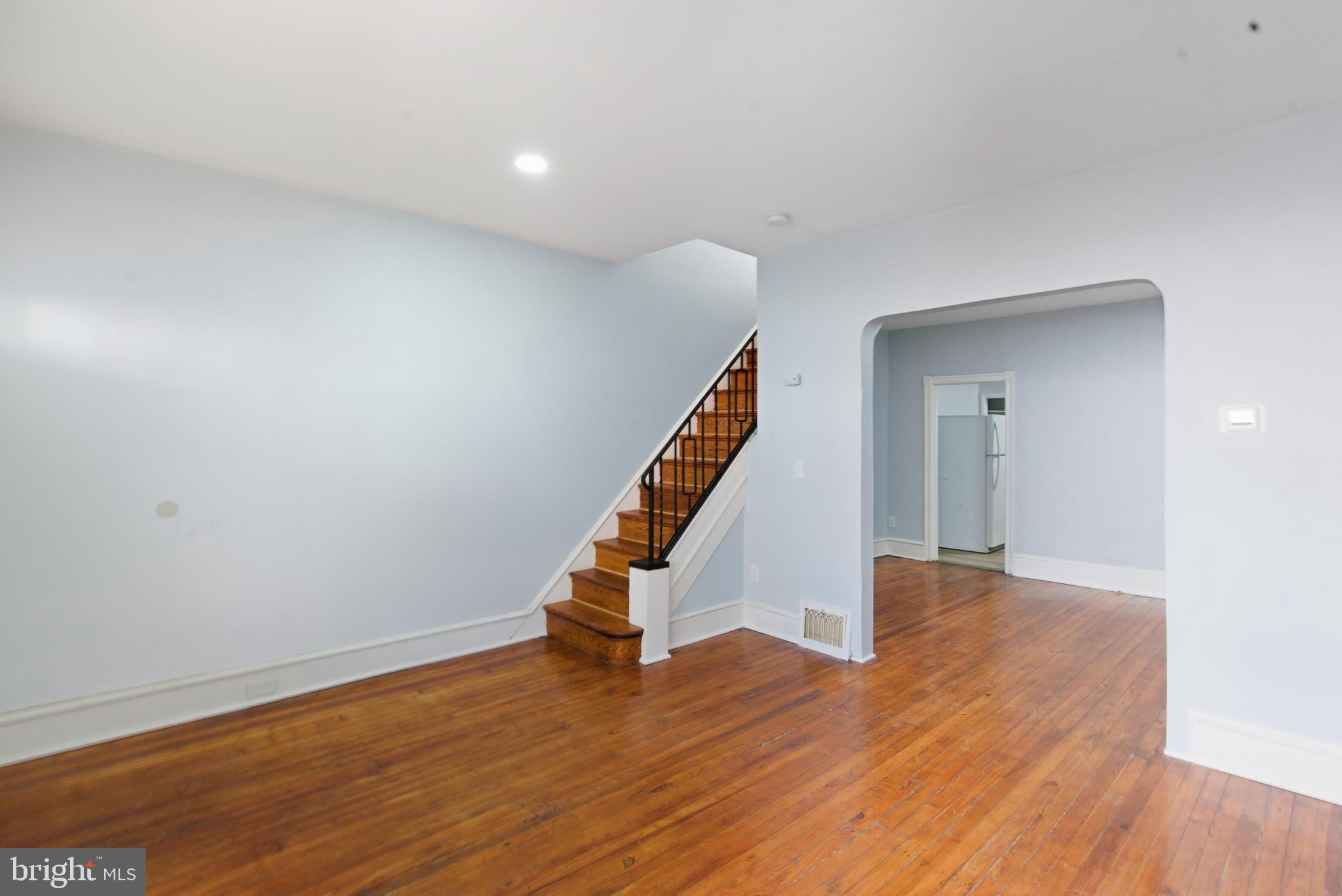 5632 Addison Street Philadelphia, PA 19143 - Photo 3 of 14 a view of an empty room with wooden floor stairs and a way
