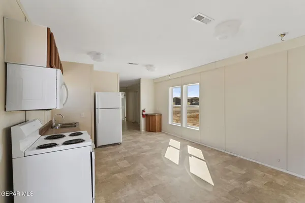 a kitchen with a stove top oven and refrigerator