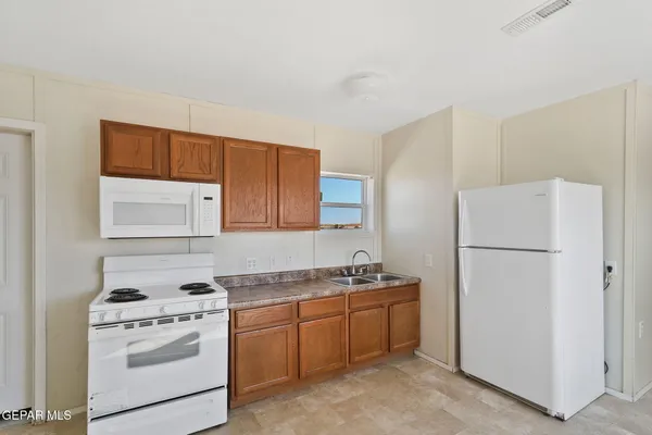 a kitchen with stainless steel appliances a stove top oven a sink a counter top space and cabinets