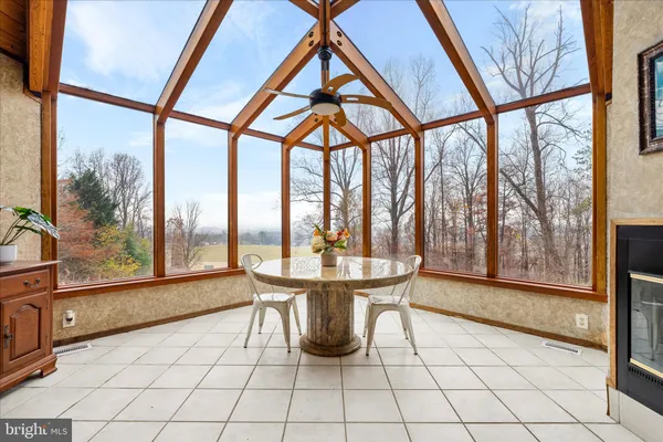 a dining room with furniture and large windows
