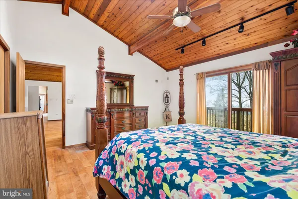 a bedroom with a bed dresser and a large window