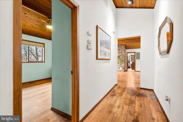 a view of a hallway with wooden floor and windows