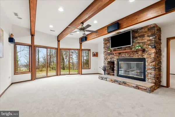 a view of an empty room with a fireplace and a flat screen tv