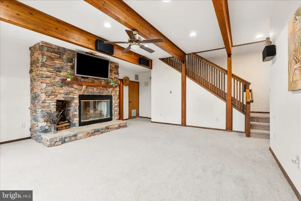 a view of an empty room with a fireplace and a window