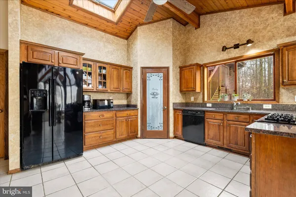 a kitchen with stainless steel appliances granite countertop a refrigerator and a stove top oven