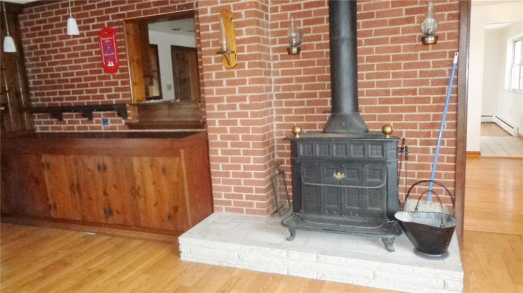 5545 Glass Road Pittsburgh, PA 15205 - Photo 10 of 18 FAMILY ROOM. Franklin Stove. Large Cabinet, with Bar on top. Brick background.