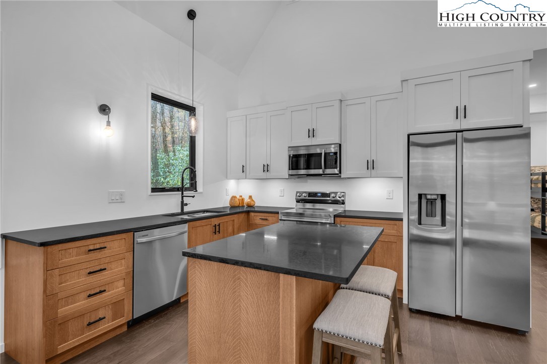 106 Jackpine Road Beech Mountain, NC 28604 - Photo 3 of 30 a kitchen with stainless steel appliances granite countertop a sink a stove a refrigerator cabinets and a window