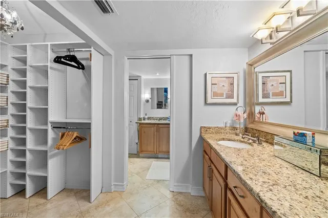 a bathroom with a granite countertop sink a mirror and a bathtub