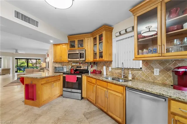 a kitchen with stainless steel appliances granite countertop a stove sink and microwave