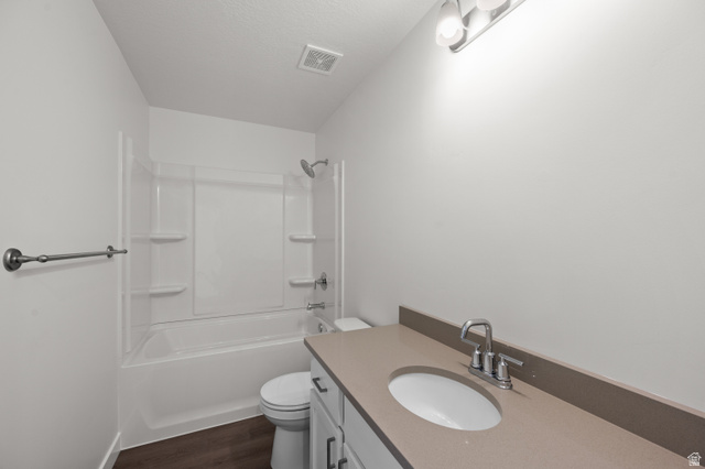 1554 Pheasant Road Eagle Mountain, UT 84005 - Photo 15 of 29 Bathroom featuring vanity, shower / tub combination, dark wood-type flooring, and a textured ceiling