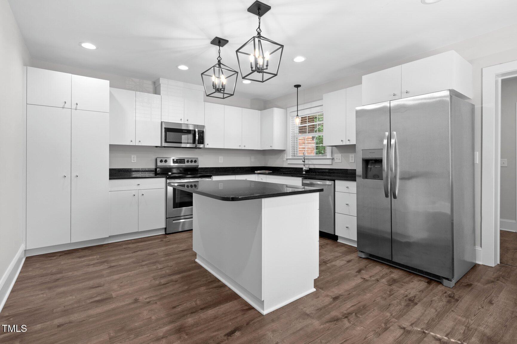 216 Whitfield Street Enfield, NC 27823 - Photo 10 of 31 a kitchen with stainless steel appliances granite countertop a refrigerator a sink a stove a microwave and wooden floor