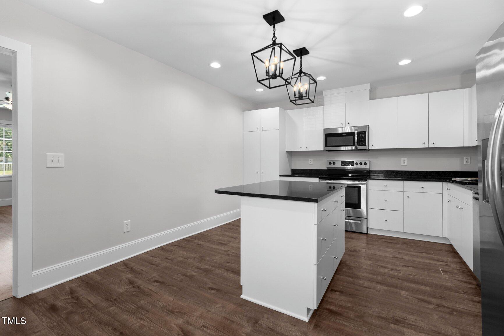 216 Whitfield Street Enfield, NC 27823 - Photo 11 of 31 a kitchen with stainless steel appliances a white stove top oven and a chandelier