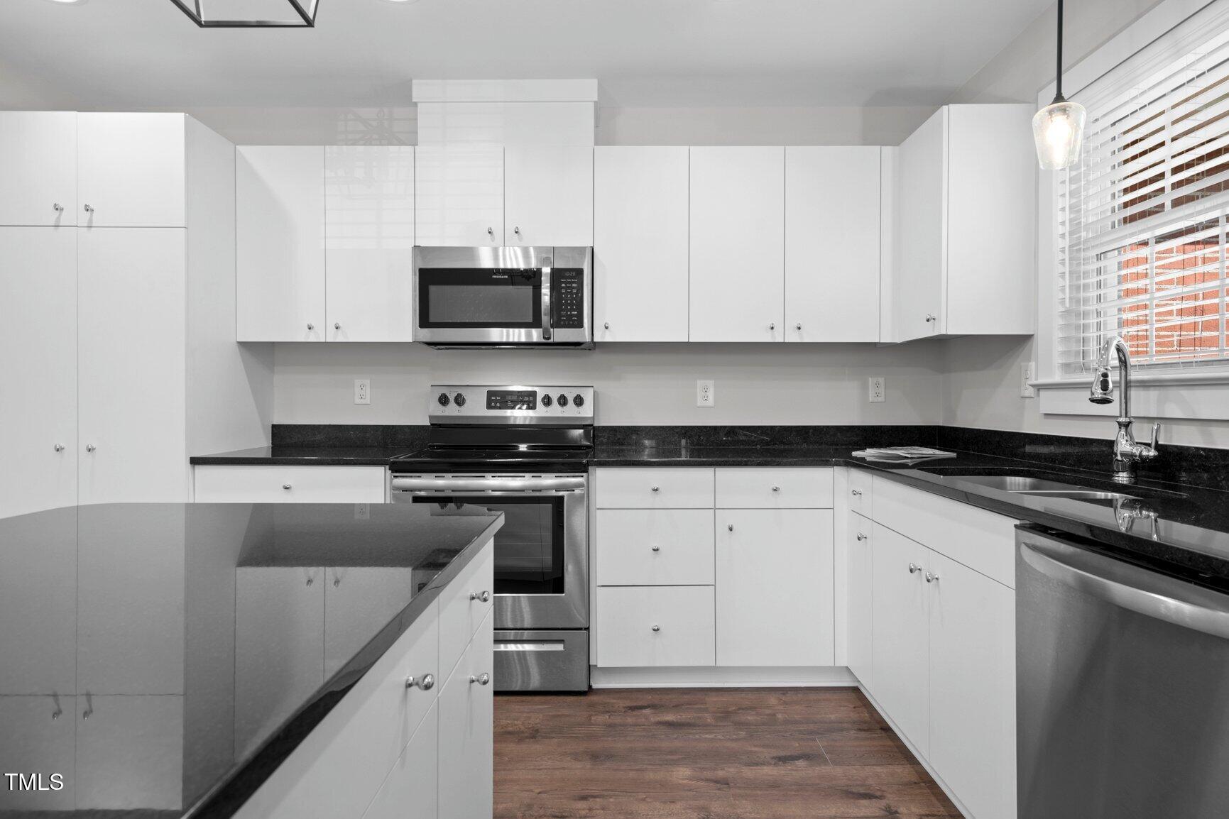216 Whitfield Street Enfield, NC 27823 - Photo 12 of 31 a kitchen with stainless steel appliances granite countertop a stove a sink and white cabinets