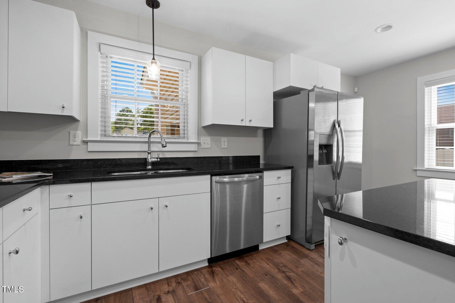 216 Whitfield Street Enfield, NC 27823 - Photo 13 of 31 a kitchen with granite countertop white cabinets white appliances a sink and a window