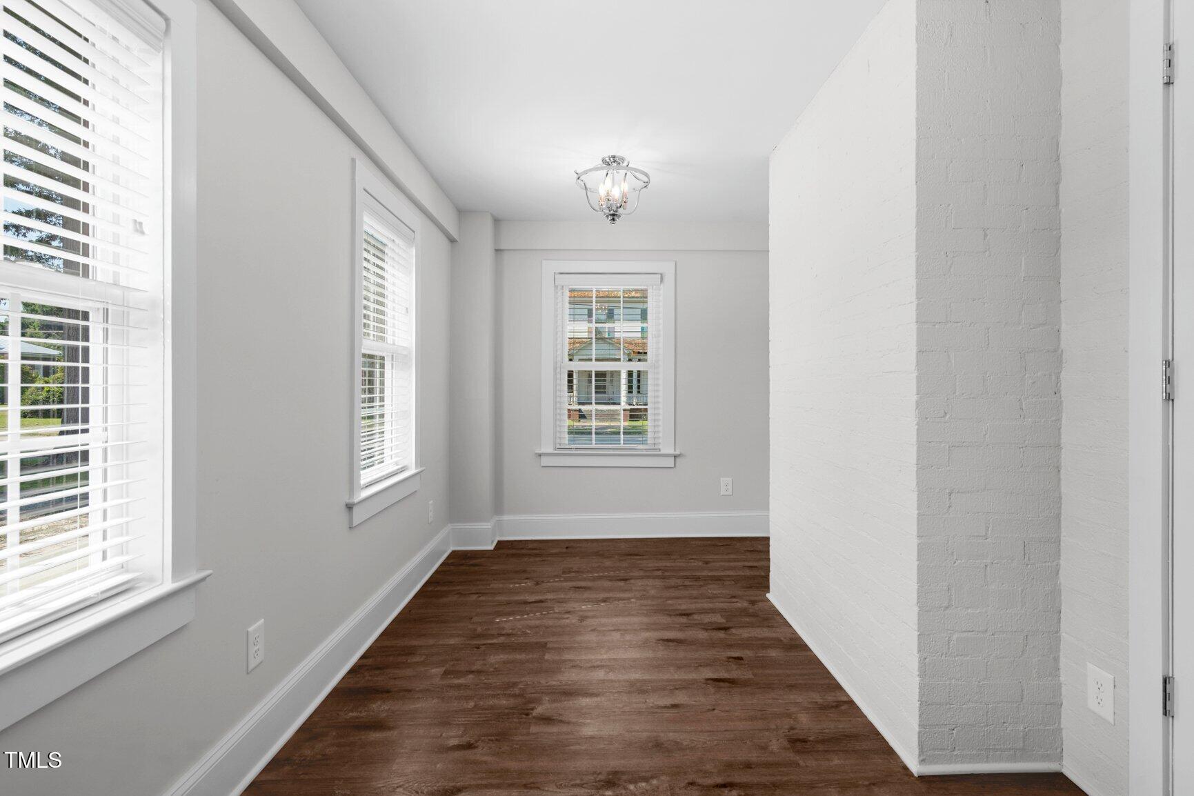 216 Whitfield Street Enfield, NC 27823 - Photo 15 of 31 a view of an empty room with wooden floor and a window
