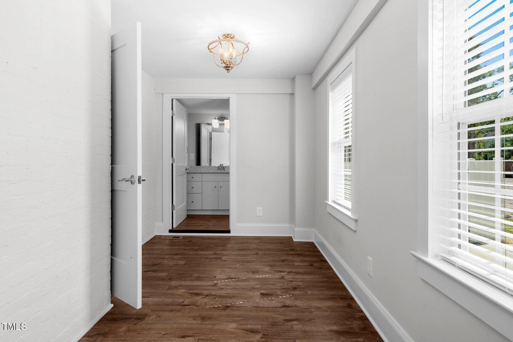 216 Whitfield Street Enfield, NC 27823 - Photo 16 of 31 an empty room with wooden floor and windows