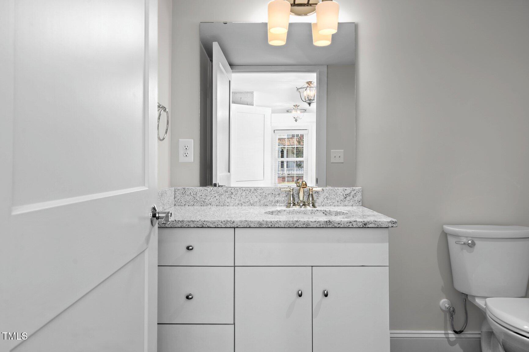 216 Whitfield Street Enfield, NC 27823 - Photo 17 of 31 a bathroom with a granite countertop sink and a mirror