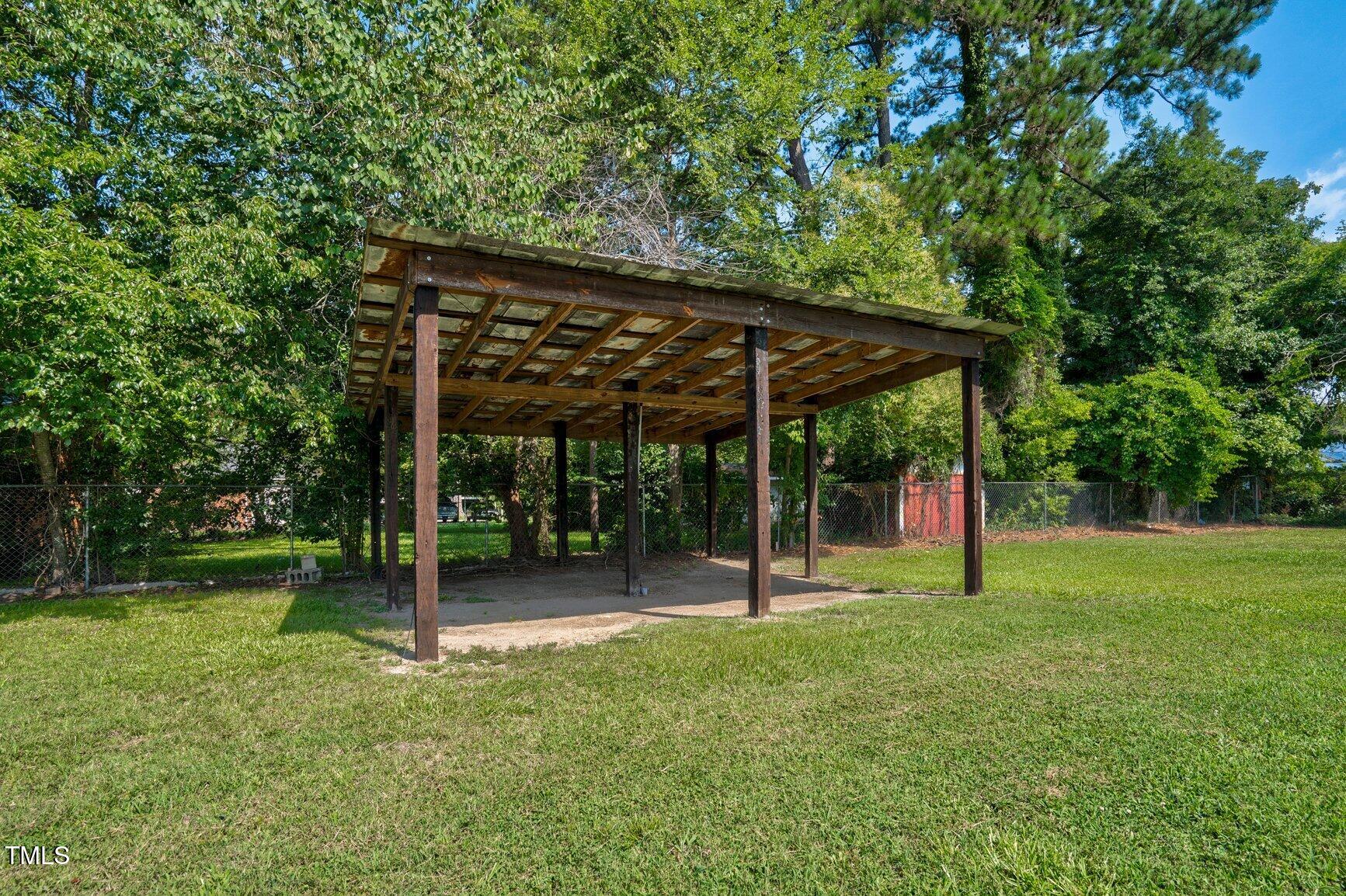 216 Whitfield Street Enfield, NC 27823 - Photo 29 of 31 a view of a backyard with a slide and large trees