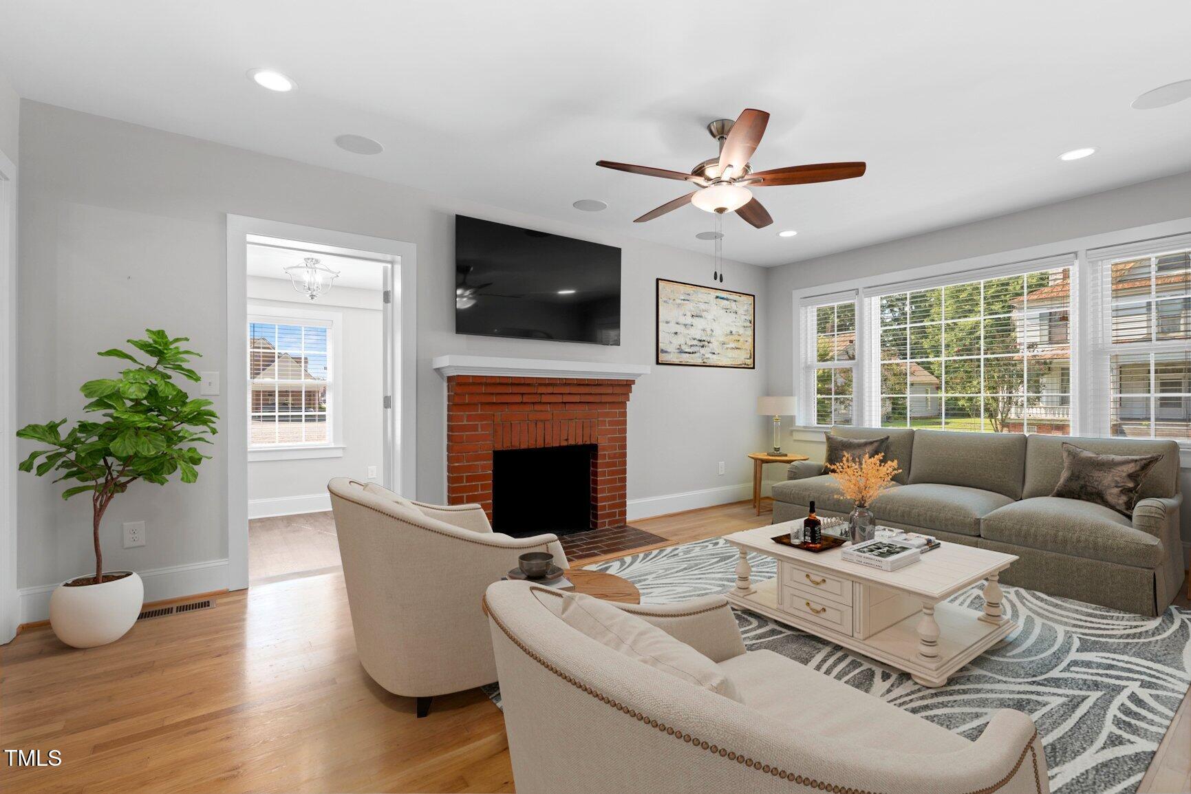 216 Whitfield Street Enfield, NC 27823 - Photo 4 of 31 a living room with furniture a fireplace and a flat screen tv