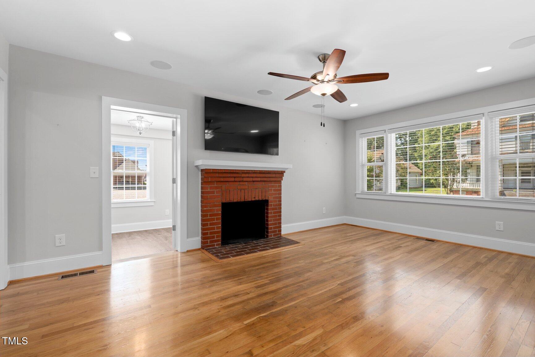 216 Whitfield Street Enfield, NC 27823 - Photo 5 of 31 a view of an empty room with wooden floor fireplace and a window